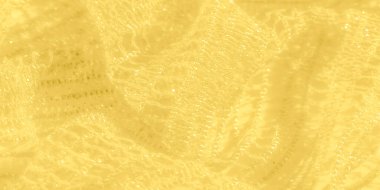 Bu sarı dantelli kumaşın ışıl ışıl doğası, ince işçiliğinin altını çiziyor. Hassas iplikler, yüzeydeki yumuşak ışık oyunuyla güçlendirilmiş güzel bir desen oluşturmak için iç içe geçiyor.