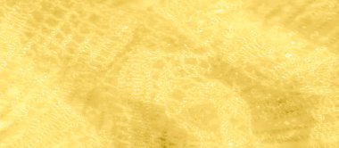 Yumuşak, sarı dantel kumaşı bulanıklaştırarak ışığı yakalar ve göz kamaştırıcı bir etki yaratır. Derinlik ve zarafetle dolu bir desen oluşturmak için narin iplikler birbirine dokuyor..