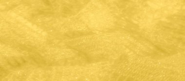 Sönmüş sarı dantel kumaş, ışıkta hafifçe parıldıyor. Kumaşın zarif dokusu, karmaşık ve zenginliği çağrıştıran gösterişli parıltılı dokuma desenlerini ortaya koyuyor..