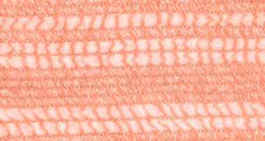 Yumuşak mercan renklerinde narin, karmaşık bir dantel kumaşın bulanıklığı. Doku, parıldayan ışıkla vurgulanır, ona rüya gibi ve ruhani bir görünüm verir..