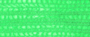 Bulanık yeşil dantel kumaş. Karmaşık, yarı şeffaf desenler. Akan kıvrımlara sarılı. Işıldayan dokusu ışığı yansıtıyor. Yumuşak ve göz kamaştırıcı bir estetik yaratıyor.