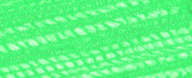 Yumuşak ışıkta yıkanmış yeşil dantel kumaş bulanıklığı karmaşık ve büyüleyici bir tasarım yaratır. Doku narindir ve yumuşak maddeye derinlik katan parlak bir görünüşü vardır.