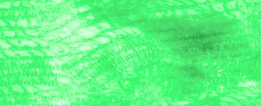 Canlı yeşil dantel kumaştan bulanık. Karmaşık dokuma ve yumuşak, akıcı bir dokusu var. Işık yüzeyde ince detaylarla parıldayan, havadar bir görüntü yaratıyor..