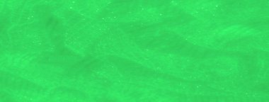 Akan, parıldayan dokuları olan yeşil dantelli bulanık kumaş. Karmaşık, şeffaf desenler, canlı yeşil tonlarla güçlendirilmiş yumuşak ve zarif bir görünüm yaratıyor..