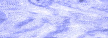 Hafif mor dantel kumaştan bulanık bir yakın çekim. Işığın yumuşak yansımalarıyla hafifçe parıldıyor. Dantel yumuşak ve havadar görünüyor. Yüzeyinde karmaşık detaylar var..