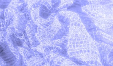 Bulanık, karmaşık dantel kumaş. Işıl ışıl bir efektle hafifçe aydınlatılmış. Kumaşın hassas ayrıntıları ve şeffaf kalitesi bir zarafet ve hafiflik hissi uyandırıyor.