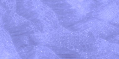 Bulanık, açık mavi dantel kumaş. Karmaşık desenler ve parıldayan dokular. Yumuşak kıvrımlar ve şeffaflık yaratıcı tasarım için ideal bir görünüş yaratır..