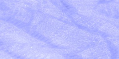 Parlak açık mavi tonda bulanık, karmaşık dantel kumaş deseni ve dokusunun ince detaylarını vurguluyor. Yumuşak ışık, kumaşın şeffaf kalitesini vurgular ve hassas bir...