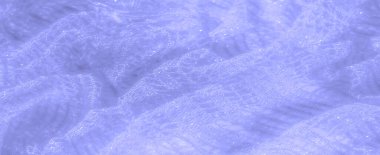 Açık mavi dantel kumaşın bulanık yakın plan görüntüsü. Karmaşık dokuma detaylarına odaklanmış. Şeffaf doku ve yumuşak eğriler, moda veya dekor kavramları için ideal, yumuşak ve lüks bir görünüm sağlar..