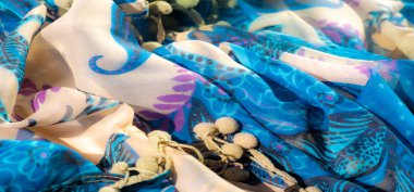 Lükslü mavi ve bej renkli kumaşlar. Artistik çiçekli ve soyut tasarımlar. Derin mavi ve mor renkte. Kalıplar canlı bir karşıtlık yaratır,