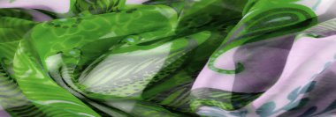 Blur Lavanta ve sanatsal çiçek desenli yeşil kumaş. Yumuşak, akışkan malzeme şifonun narin doğasını ve zarif kumaşını vurgular..