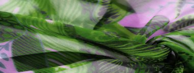 Soyut botanik desenlerle süslenmiş lavanta yeşili bir kumaş. Hafif kumaş yumuşak bir şekilde dalgalanır, zarif ve havadar bir estetik yaratır ve bu da şık kıyafetleri tamamlar..