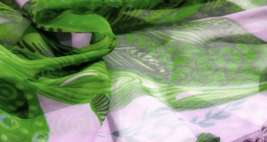 Yemyeşil ve lavanta renkli şifon kumaş bulanıklığı, soyut yaprak benzeri desenler içeriyor. Kumaşın yumuşak akışı bir hareket ve zarafet hissi yaratır..