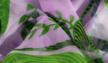 Lavanta tabanı üzerinde koyu yeşil yaprak motifleri olan canlı bir kumaş. Akan malzeme organik ve detaylı desenleri vurgular, bahar temalı tasarımlar veya açık renk giysiler için mükemmeldir..