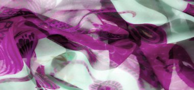 Kumaşın bulanık görüntüsü zengin bir mor ve nane yeşili palet ve karmaşık çiçek desenleri sergiliyor. Sıvı, saf madde ışıkla dans eder, katmanlı, sanatsal görsel bir etki yaratır..