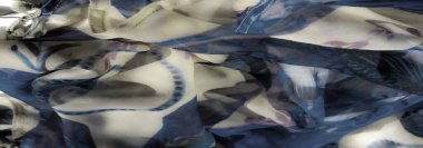 Mavi, bej ve mor aksanlı, kıvrımlı çiçek desenli güzel bir kumaşın bulanıklığı. Yumuşak malzeme kıvrımları moda için ideal şekil ve renklerin büyüleyici bir karışımını yaratır.