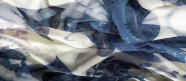 Güzel mavi ve bej kumaşlı, soyut çiçek aksanlı bir bulanıklık. Akan tasarım ince, sanatsal hareketleri ve yumuşak materyal üzerindeki kalıpların etkileşimini yakalar..