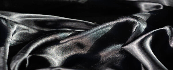 Размытость мягкого, струящегося черного цвета с тонкими световыми подсветками. Гладкий материал создает богатый визуальный вид с гладкой, глянцевой поверхностью, которая привлекает внимание.