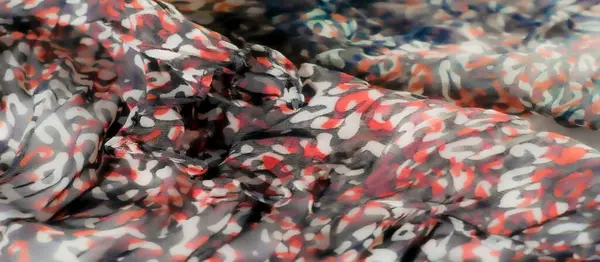 Görüntü: Kırmızı, siyah ve beyaz desenli, yumuşak kıvrımlı ve ince röfleli güzel bir kumaş. Tasarım canlı ve karmaşıktır, yarı-katıksız dokusuyla