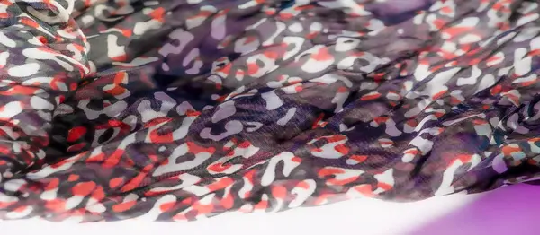 Saf bir kumaşın bulanık, soyut, düzensiz desenler kırmızı, mor ve siyah tonlarda. Şeffaf madde dinamik ve canlı renklerini vurgulayan katmanlı, akışkan bir doku yaratır.