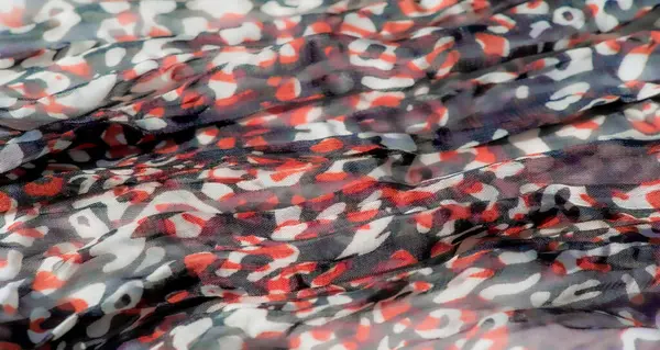 Saf kumaştaki parlak kırmızı, beyaz ve siyah desenlerin bulanık detaylı görüntüsü. Üst üste binen katmanlar zengin, soyut bir tasarım yaratıyor. Moda, sanat ve yaratıcı tasarım için ideal..