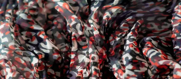 Saf kumaştaki parlak kırmızı, beyaz ve siyah desenlerin bulanık detaylı görüntüsü. Üst üste binen katmanlar zengin, soyut bir tasarım yaratıyor. Moda, sanat ve yaratıcı tasarım için ideal..