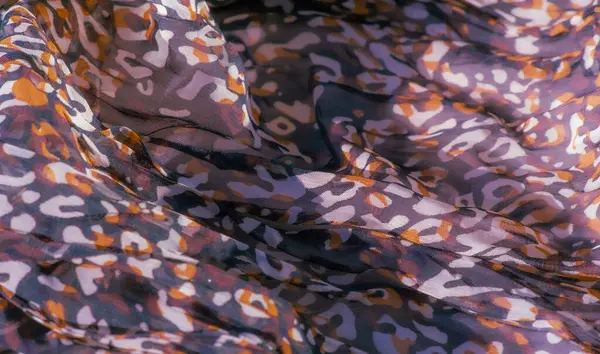 Kırmızı, siyah ve beyaz akışkan kumaşın bulanık sanatsal görüntüsü, soyut leopar benzeri baskılar içerir yumuşak, katmanlı doku boyutu ekler ve bunu sanatsal projeler için çarpıcı bir seçim haline getirir.