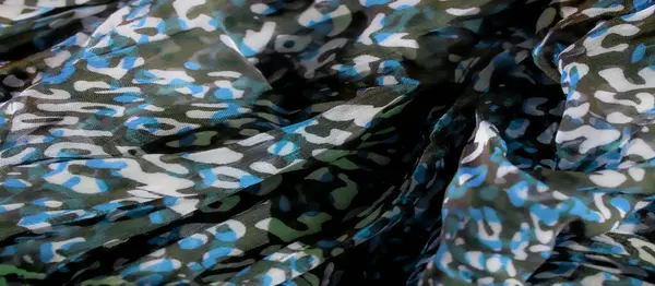 Yumuşak kıvrımlı mavi, beyaz ve yeşil tonlarda canlı bir kamuflaj kumaşı. Soyut desen, tekstil tasarımı için ideal derinlik ve hareket dinamik bir his yaratır..
