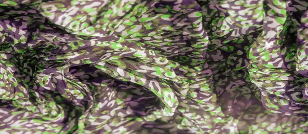 Bulanık, dinamik yeşil ve siyah soyut desenler yumuşak bir ağ kumaşı boyunca akar ve büyüleyici bir doku tasarımı yaratır. Renklerin ve soyut şekillerin karışımı resme derinlik ve hareket ekler