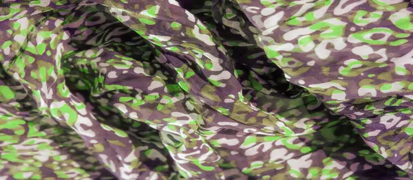 Bulanık, soyut yeşil ve koyu desenler yumuşak, akan bir kumaşa yayılmış. Organik şekiller uyum içinde harmanlanarak, derinlik, hareket ve sanatsal akışkanlık hissi ekliyor..