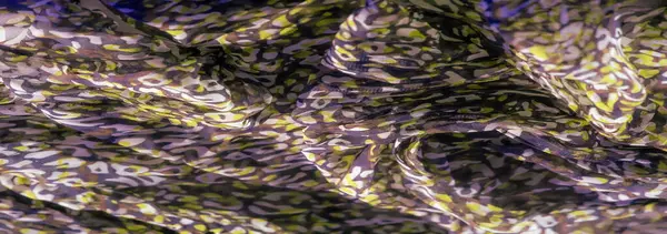 Kumaş üzerinde mor ve sarı soyut desenlerle karışık kıvrımlar, organik akışla zengin, dokulu bir yüzey yaratarak hem derinlik hem de kontrastlık sunar..