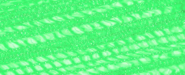 Yumuşak ışıkta yıkanmış yeşil dantel kumaş bulanıklığı karmaşık ve büyüleyici bir tasarım yaratır. Doku narindir ve yumuşak maddeye derinlik katan parlak bir görünüşü vardır.