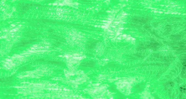 Işıldayan bir dokusu olan yeşil dantel kumaş bulanıklığı. Karmaşık örülmüş desen yumuşak kıvrımlarla akar, ışığı ruhani ve dekoratif bir şekilde yansıtır..