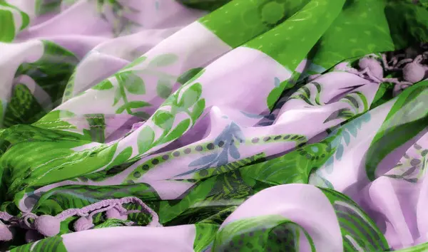 Bulanık lavanta ve zarif çiçek desenli yeşil katıksız kumaş. Işık ve kıvrımların oyunu yumuşak, akışkan bir etki yaratır. Maddenin hassas ve canlı doğasını yakalar..