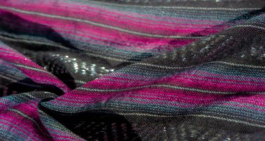 Siyah, mor ve mavi kumaştan oluşan iç içe geçmiş çizgileri bulanıklaştırın. Zengin dokular ve metalik iplikler derinlik ve zarafet ekler, tekstil ilhamı veya moda tasarımları için mükemmeldir..