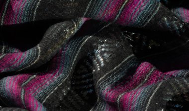 Renkli pembe ve turkuaz çizgili, ince parıltılı detaylarla zenginleştirilmiş siyah kumaş bulanıklığı. Katlanmış kumaş karmaşık kıvrımlar ve gölgeler yaratır ve zarifliğini arttırır.