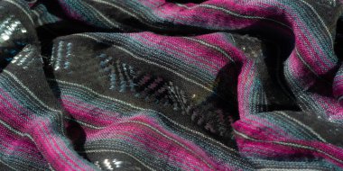 Parlak pembe ve mavi aksanlı bulanık siyah kumaş, çizgili bir desen ve parlak yansıtıcı iplikler içeriyor. Dokulu yüzey, kumaşların yumuşaklığını ve lüksünü arttırır..