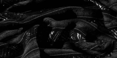Karmaşık çapraz çizgileri olan bulanık kumaş ve parlak röfleler. Siyah madde dokuma ve yükseltilmiş dokuların karışımını gösteriyor. Zarif ve dokunaklı bir görsel deneyim yaratıyor..