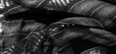 Görüntü, karmaşık yansıtıcı detaylara sahip siyah ve gri çizgili kumaş. Örülmüş zigzag desenleri derinliği artırıyor ve bu çok yönlü materyale parlak, üst düzey bir his veriyor..