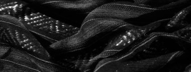 Parlak, dokunmuş geometrik detaylarla örtülü kumaşın bulanık görüntüsü. Parlak iplikçiklerdeki ışık oyunu kumaşa lüks bir dokunuş katıyor. Dinamik ama zarif bir görünüm yaratıyor..