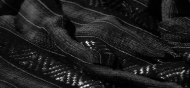 Bulanık siyah ve beyaz çizgili kumaş, ince parıldayan dokular, kumaşa derinlik ve boyut ekleyen alternatif desenler sergiliyor.