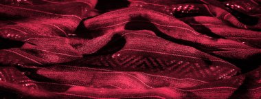 Işığı yansıtan parlak, detaylı desenli kırmızı desenli bulanık kumaş, derinlik ve zarafetle dolu göz alıcı ve canlı bir görüntü yaratıyor..