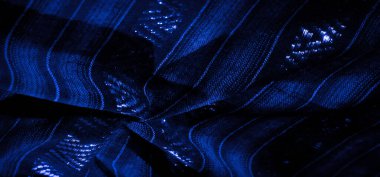 Bu mavi kumaşlar üzerindeki ışık ve karanlık zıtlıkların etkileşimini bulanıklaştırarak karmaşık dokuma desenini ve ince parıltısını vurguluyor, modern zarafeti çağrıştırıyor..
