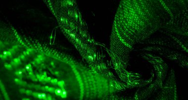 Parlak ışıklarla aydınlatılmış parıldayan yeşil kumaş kıvrımları bulanıklaştırır. Karmaşık dokular ve fütüristik ve dinamik enerji saçan soyut desenler yaratır..