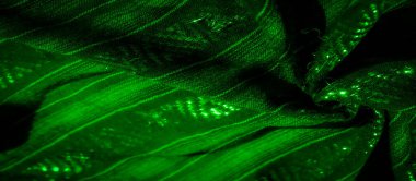 Karmaşık dokuma desenleri ve parıldayan ışıkla aydınlık yeşil kumaşı bulanıklaştırarak hem dokuyu hem de enerjik enerjiyi birleştiren büyüleyici bir soyut bileşim yaratır..