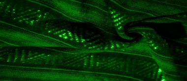 Geometrik desenlerle örülmüş yeşil kumaş kıvrımlarını bulanıklaştırır. Parlayan ışıklarla hafifçe aydınlatılır. Boyut ve derinlik dolu akışkan ve hipnotik bir soyut tasarım yaratır..