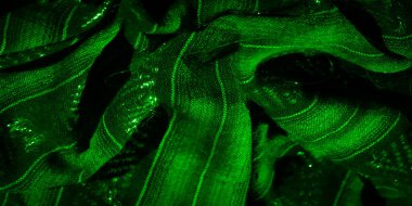 Dokuma kumaşının ve parıldayan desenlerin etkileşimini bulanıklaştırarak, kumaşın dokusunu ve parlak detayları vurguluyor. Soyut düzenleme ışıldayan liflerle dinamik dokuya hayat veriyor..