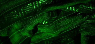 Karmaşık parlak desenli, dokulu yeşil bir kumaş, büyüleyici ve soyut bir estetik yaratıyor. Parlak detaylar kumaşın karmaşıklığını ve zarafetini katlar.