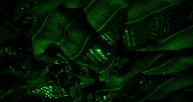 Parlak detaylarla parlayan katlanmış yeşil kumaşın sanatsal bir görüntüsü soyut ve dokulu bir etki yaratarak parlak deseni ve katmanlı tasarımı ile dikkatleri çeker..