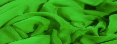 Karmaşık kıvrımları ve ince şeffaflığı olan yeşil kumaş bulanıklığı soyut ve akışkan bir desen oluşturuyor. Kumaş ışığı yakalar, sıvı dokusunu ve derinliğini arttırır..